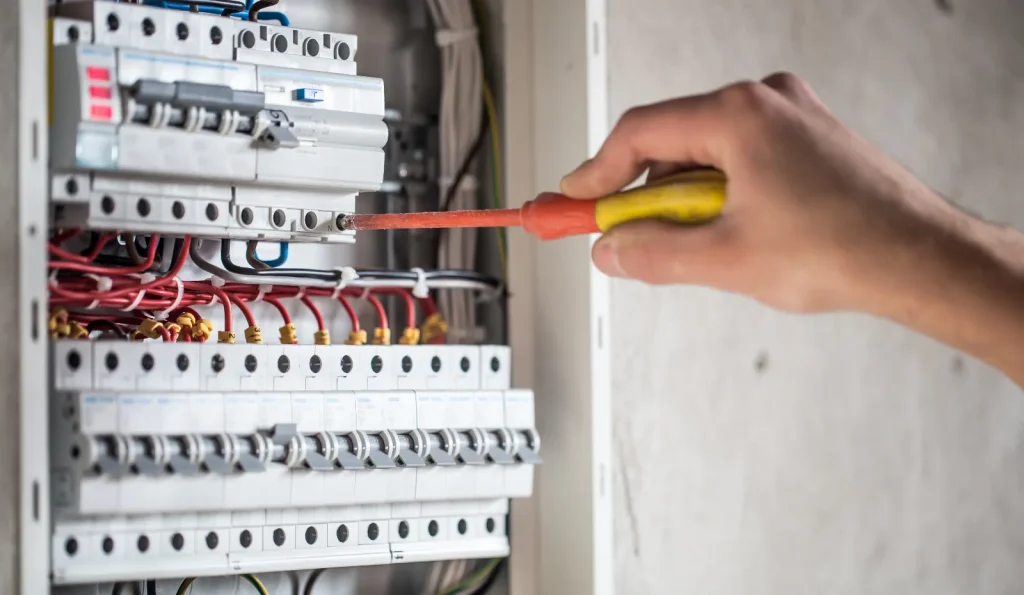 Électricien vérifiant les protections d'un tableau électrique